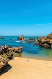 The beautiful Plage du Port Vieux on a summer afternoon where bathers can be seen bathing.