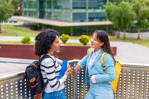 Latin and chinese female beauty students talking outside the campus of the university