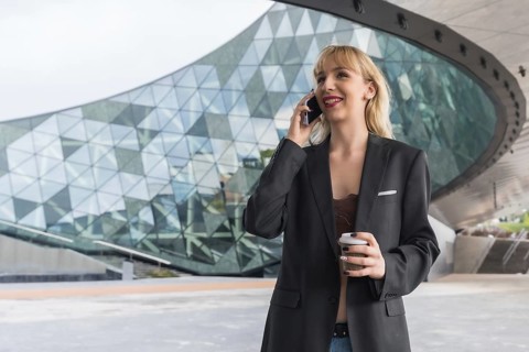Entrepreneur girl business park in a modern building with colored glass, young blonde smiling in
