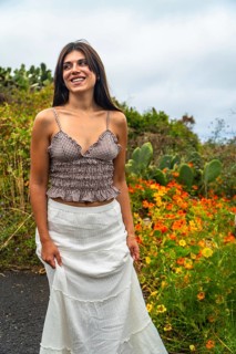 Young woman standing by a path in el hierro, canary islands, smiling and looking away, surrounded