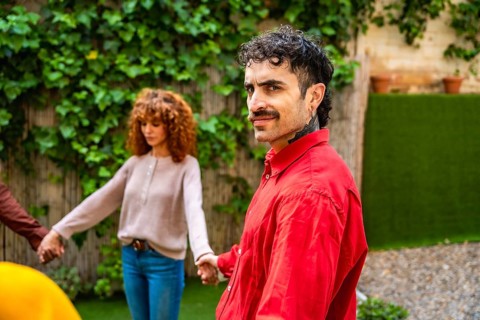 Diverse group of people holding hands in a supportive circle during an outdoor therapy session in a
