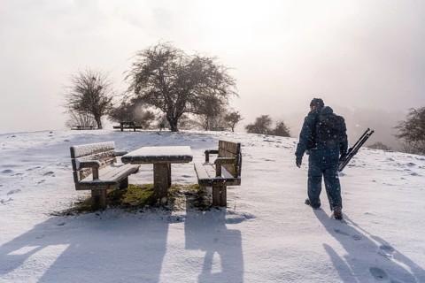 A young photographer at dawn in the picnic area next to the refuge of Mount Aizkorri in Gipuzkoa.