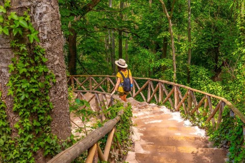 A woman with a hat walking down the stairs in the Monasterio de Piedra Natural Park, Aragon