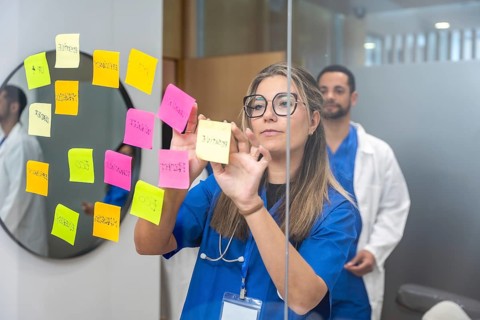 Medical team collaborating and developing healthcare strategies, sticking colorful notes with