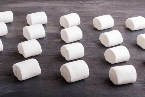 Set of marshmallows on black wooden background. top view, flat lay. geometric pattern