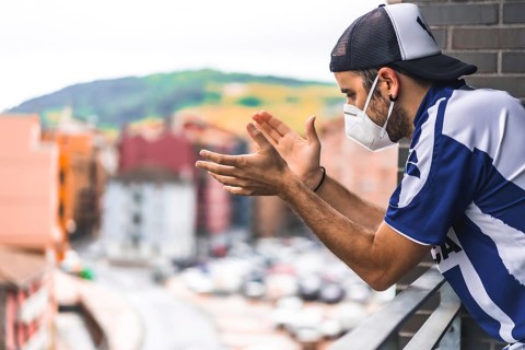 A young man in a mask applauding the toilets on the balcony at 8 in the afternoon. Pandemic