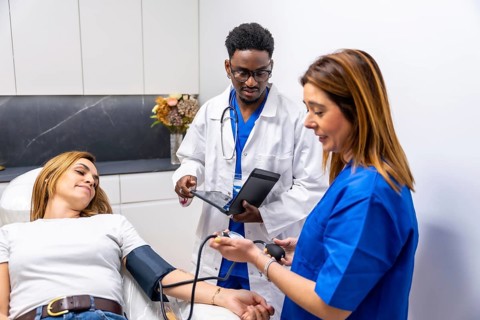 Medical team monitoring a woman's blood pressure during a diagnostic examination at a modern