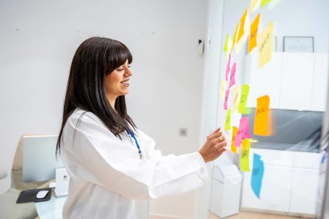 Female doctor in a white coat brainstorming and planning healthcare strategies, organizing ideas