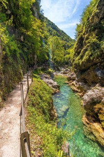 Tolmin gorge in slovenia features crystal clear turquoise water flowing through a narrow canyon,