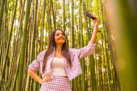 Young caucasian girl with a pink skirt in a bamboo forest. Enjoying summer vacation in a tropical