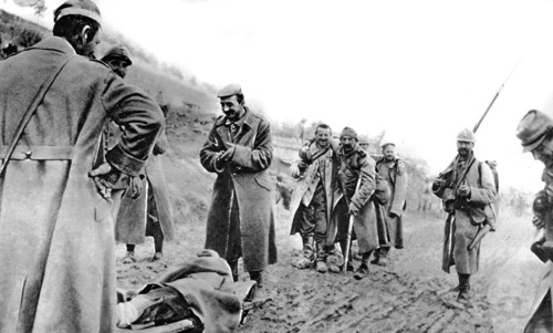 World War I. In Champagne, after the battle, able-bodied prisoners help wounded French soldiers reach an ambulance (1915)