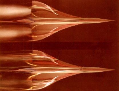 Visualization, in the hydrodynamics tunnel of the O.N.E.R.A., of low-speed airflow around the model of a low-incidence supersonic transport. Above: without simulation of the jet engines. Below: with s...
