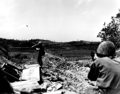 The Pacific War in Okinawa: American Marine throwing a grenade towards the Japanese lines