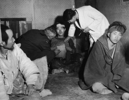 Refugees from Koje island. Doctor Henri Meyer examines a refugee suspected to have contracted typhus