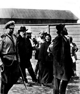 Russian revolutionaries leaving for Siberia. A woman sticks out her tongue at the photographer. A man holds a bouquet that a friend gave him