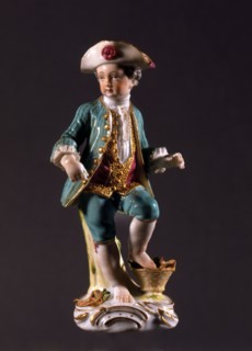 Figurine of a boy with a basket of vegetables.