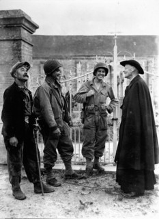 Deux soldats américains discutent avec un curé français à Nucilly en Normandie 1944.