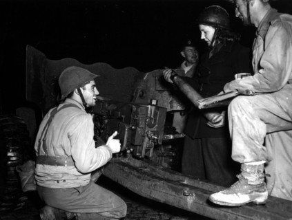 Une jeune femme des Forces françaises de l'intérieur charge un canon dans la région de Belfort. (24 novembre 1944)