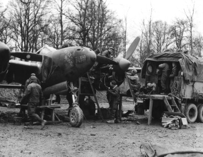 L'équipe de maintenance de la 9e U.S Air Force effectue la révision d'un chasseur-bombardier "P-38 Lighting" (Belgique, décembre 1944)