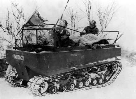Des hommes du corps médical américain évacuent un blessé en ambulance.
(1er février 1945)