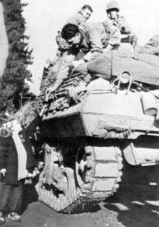 A 1st French Army tank crew gives a chocolate bar to a French girl in Couthenans area, November 1944