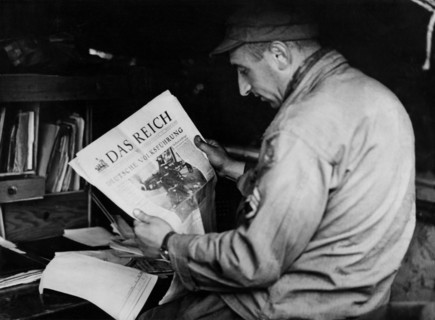 An American soldier read a Nazi newspaper in Carentan (France) June 1944
