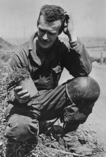 American soldier examines a German mine in Normandy, July 1944