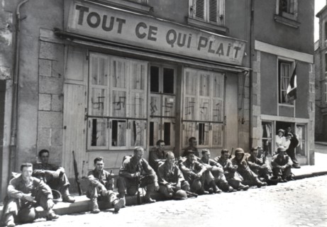 American soldiers rest on Laval curbstone, August 1944