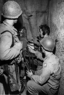 Soldats américains du Corps des transmissions installant des lignes de communication à Saint-Lô.
(Juillet 1944)