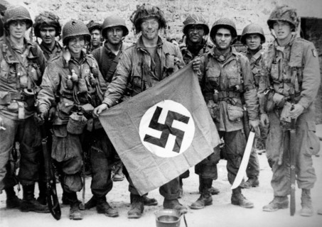 Un groupe de parachutistes américains exhibe un drapeau Nazi (juin 1944)
