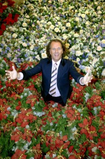 (dpa) - Dutch star violinist Andre Rieu smiles while standing in a sea of artificial flowers in