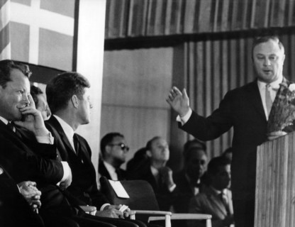 Leber hands over a bunch of carnations to Kennedy