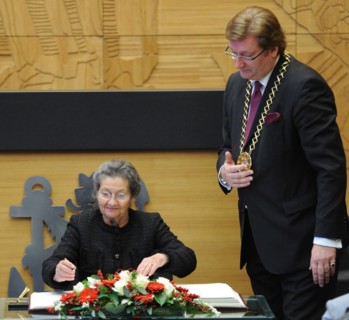 French politician Simone Veil (L) signs in a book after being awarded with the Heinrich Heine