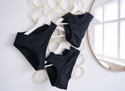Period underwear hangs on hangers in a room. (posed scene) Period panties are increasingly