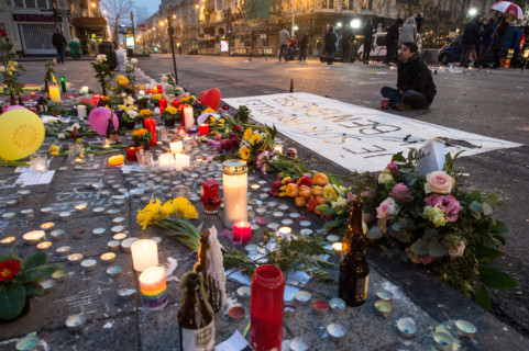 A man mourns next to a banner that reads 'Je suis Bruxelles Ik ben Brussel' (lit. I am Brussels) in