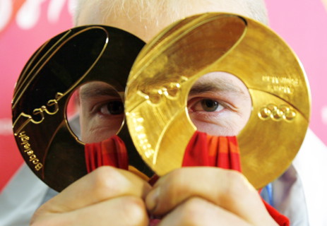 (dpa) - German Andre Lange looks through his two gold medals at the Olympic bobsleigh and toboggan