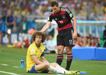 Germany's Miroslav Klose (R) helps up Brazil's David Luiz during the FIFA World Cup 2014 semi-final