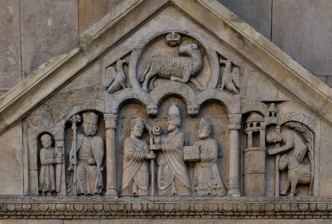 Fidenza, duomo (Cattedrale di San Donnino), portale sinistro, timpano. Nel frontone si leggono, da