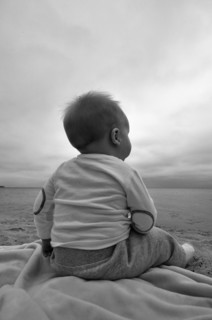 Baby Boy Sitting on Beach, Rear View