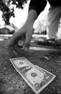 Man Picking Up Dollar Bill From Ground