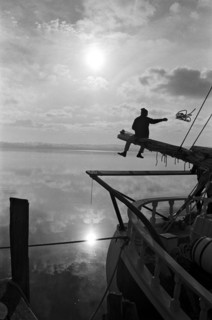 Sailor Sitting on Pole on Sailboat
