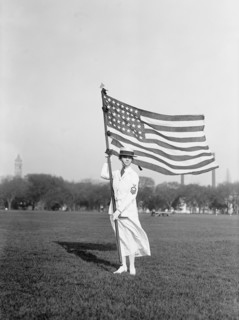 Female Navy Yeoman in White Summer Dress Uniform Holding American Flag, USA, Harris & Ewing, 1917
