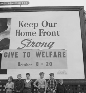 Group of Boys under Billboard, their Fathers work in nearby Defense Plants, near Lititz, Pennsylvania, USA, Marjorie Collins for Office of War Information, November 1942