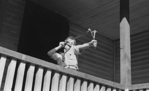 Young Boy Shooting Slingshot from Porch, near Buckhorn, Kentucky, USA, Marion Post Wolcott for Farm Security Administration, September 1940