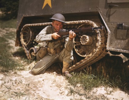 Young Soldier Aiming Garland Rifle near Armored Tank, Fort Knox, Kentucky, USA, Alfred T. Palmer for Office of War Information, June 1942