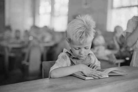 Young Boy Reading Book in Classroom, Cumberland Mountain Farms, near Scottsboro, Alabama, USA, Carl Mydans for U.S. Resettlement Administration, June 1936