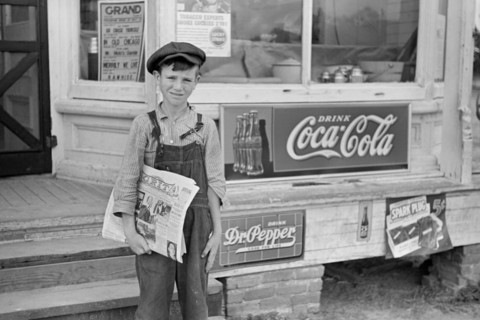 Farm Boy Selling Newspapers in front of General Store, Irwinville Farms, Georgia, John Vachon for Farm Security Administration, May 1938