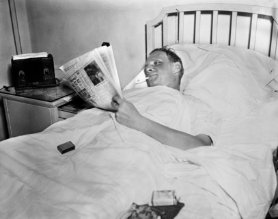 Man Smoking Cigarette while Reading Newspaper in Hospital Bed, Harris & Ewing, 1936