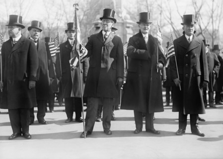 President Woodrow Wilson (center), Vice President Thomas Marshall to Wilson's left, Holding American Flags during Parade Honoring Wilson's Return from Paris Peace Conference, Washington DC, USA, Harri...
