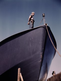 Coast Guard Sentry Standing Watch over New Torpedo Boat Under Constructions at Shipyard, Higgins Industries, Inc., New Orleans, Louisiana, USA, Howard R. Hollem for Office of War Information, July 194...